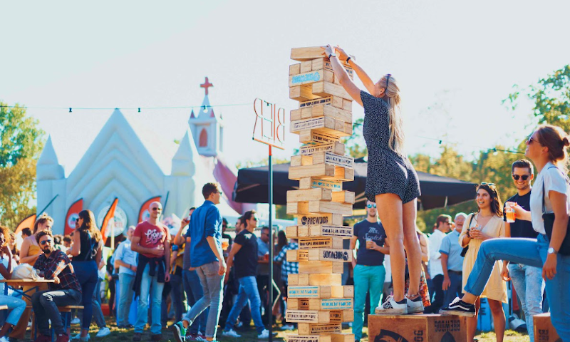 Meisje bouwt toren tijdens het TAPT Festival terwijl anderen toekijken
